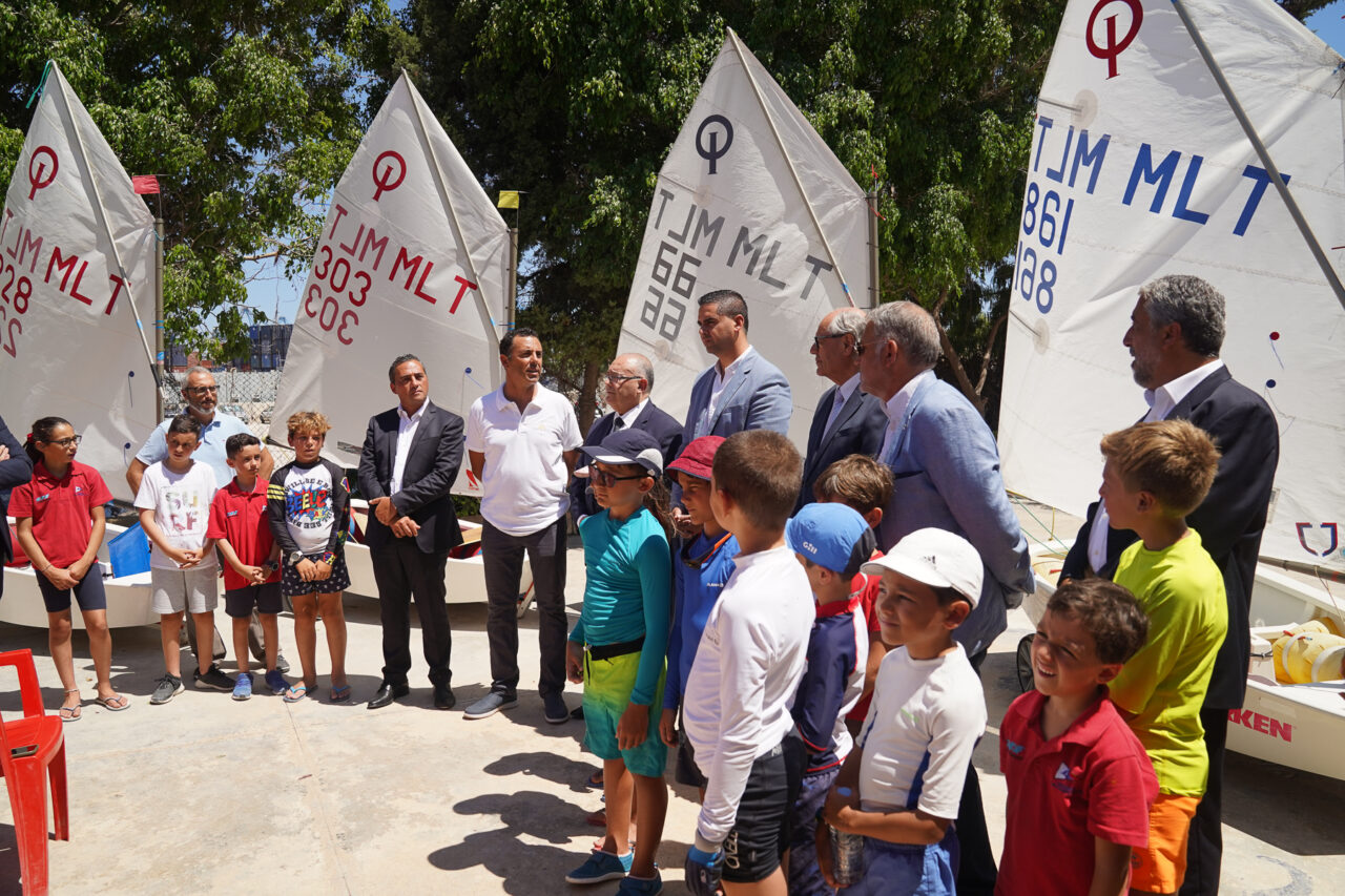 Young sailors and officials with Optimist dinghies at the launch of the Yachting Malta Sustainability Plan, Birżebbuġa