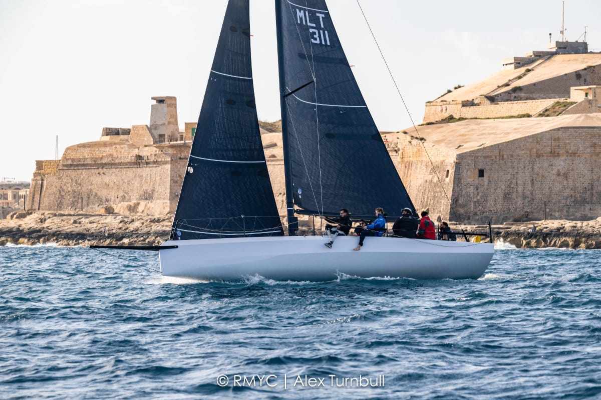 A yacht sails past the fortifications at the start of the Marzamemi Race
