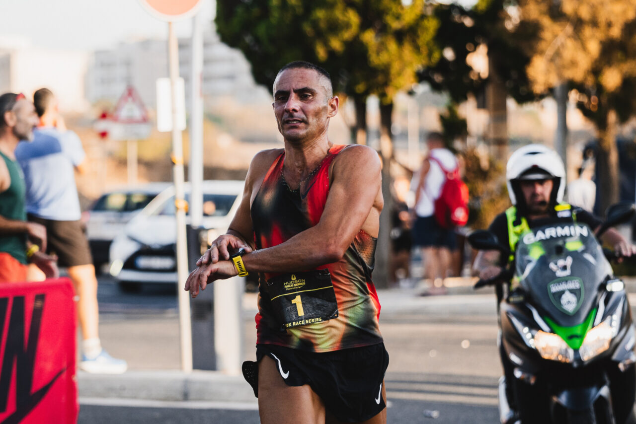 A runner checking his watch near the finish in Burmarrad