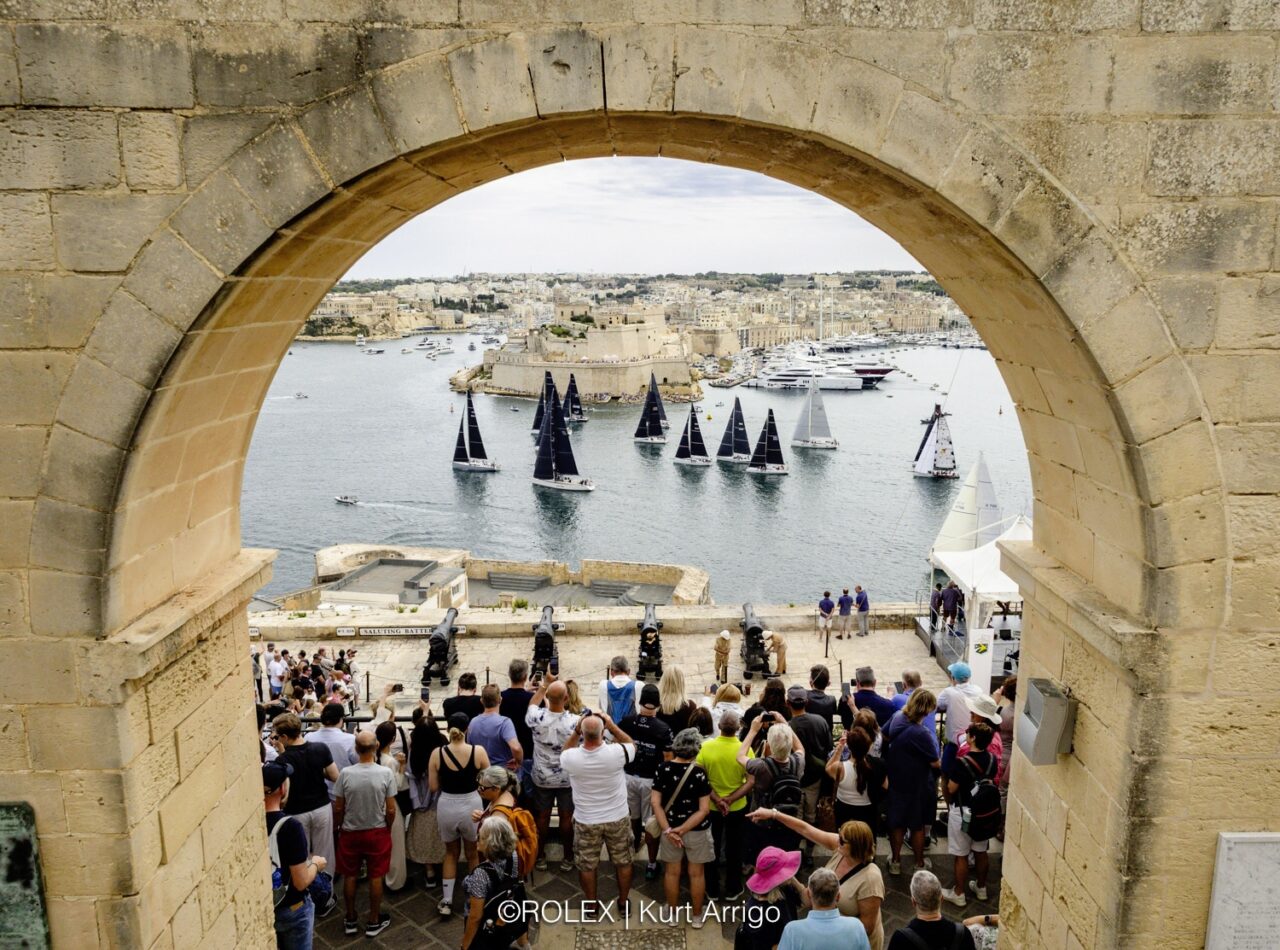 Yachts at the start of the 46th Rolex Middle Sea Race in Grand Harbour, seen through an arch of the Upper Barrakka Gardens